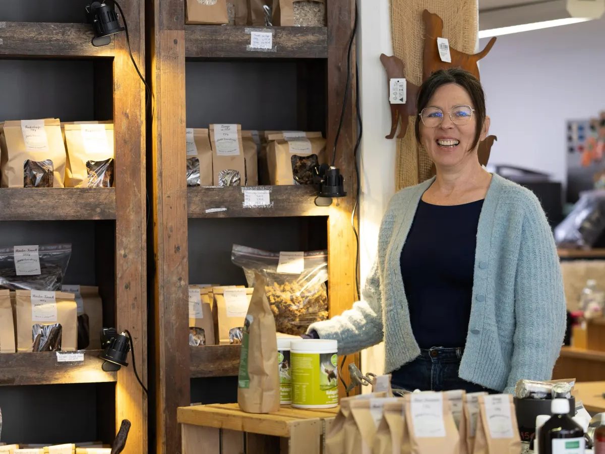 Petra Klein im Laden vor Regalen mit handgefertigten Kauartikeln